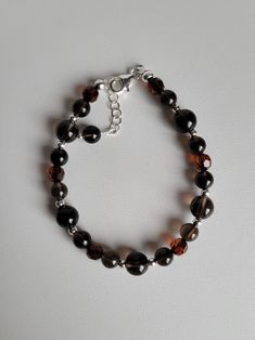 "This bracelet features Smoky Quartz gemstones, a dark brown color and is known to calm emotions and protect against external stresses. Also in the bracelet are Swarovski dark brown crystal beads and sterling silver beads and findings. It has a 1\" extension with a beaded drop making it adjustable. Custom Orders are always welcome! Ask about free sizing." Brown Smoky Quartz Jewelry With Natural Stones, Brown Crystal Bracelet With Gemstone Beads, Brown Crystal Bracelet With Gemstone Beads For Healing, Brown Round Beaded Crystal Bracelet As Gift, Brown Gemstone Beads Crystal Bracelet For Healing, Brown Beaded Round Crystal Bracelet, Brown Crystal Bracelet With Faceted Round Beads, Elegant Brown Beaded Bracelets With 8mm Beads, Brown Faceted Beads Bracelets As Gift