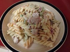 a plate with pasta salad on it sitting on a table