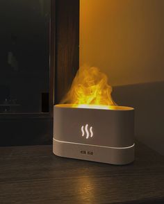 a white and gray device with yellow flames on it's side sitting on a table