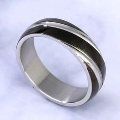 On your wedding day, honor the man you love with this elegant band. Created in titanium steel, this band features two diagonal rows set cleverly on the black band. A handsome look, this meaningful wedding band is finished with a bright polished shine.Weight: 4 gWidth: 6 mmMaterial: Plating Color: Silver Elegant Black Tungsten Carbide Rings, Black Titanium Anniversary Rings, Formal Black Titanium Jewelry, Black Stainless Steel Promise Ring, Black Stainless Steel Couple Rings For Promise, Mens Black Ring, Wedding Band For Men, Men's Wedding Bands, Black Wedding Band