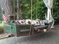 an old wooden boat is hanging from a tree