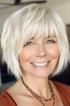 Wispy Platinum Layered Bob Haircut on a smiling woman with platinum blonde hair. Short Platinum Bob With Bangs, Layered Bob Bangs Hairstyles, Shaggy Straight Short Hair, French Bob For Over 60, Short Choppy Bob Hairstyles With Bangs, Layered Chin Length Bob With Bangs, Feathered Bobs For Fine Hair, Short Layered Bob With Fringe