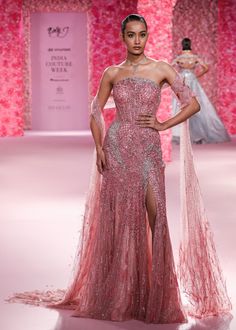 a model walks the runway in a pink gown