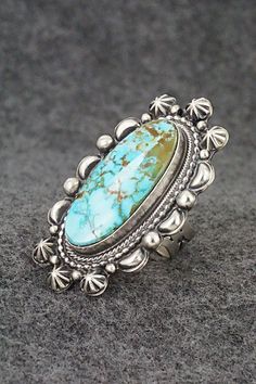 This beautiful Kingman turquoise and sterling silver ring was made by Navajo silversmith Tom Lewis. The back is signed and stamped sterling.Size: 7.5Length: 2"Width: 1 1/8"Free shipping on all orders! We ship with USPS and always include tracking. All orders ship within a day of payment.Returns are accepted up to 30 days after you receive your order. Just send us a message. Our shop offers cash back or store credit. The item must be returned in new condition. Southwestern Style Large Turquoise Ring For Anniversary, Southwestern Style Large Stone Turquoise Ring For Anniversary, Sterling Silver Turquoise Concho Ring, Western Sterling Silver Turquoise Ring With Patina, Western Sterling Silver Turquoise Concho Ring, Silver Oval Turquoise Ring With Concho Detail, Silver Oval Turquoise Ring With Concho, Collectible Western Style Turquoise Ring Stamped 925, Untreated Silver Turquoise Ring In Southwestern Style