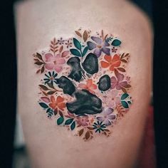 a woman's thigh with an animal paw and flowers tattoo on her side ribcage