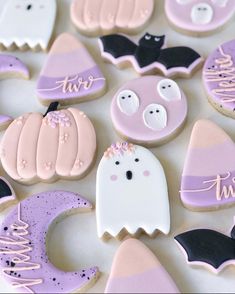 some decorated cookies are laying out on a table with bats, ghost and pumpkins