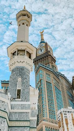 a tall tower with a clock on it's side in front of other buildings