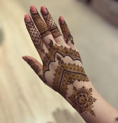 a woman's hand with henna tattoos on it