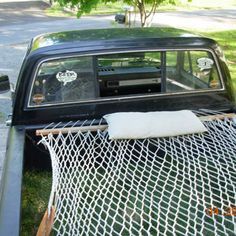 an old pick up truck with a hammock in the bed