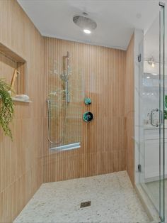 a walk in shower sitting next to a white sink