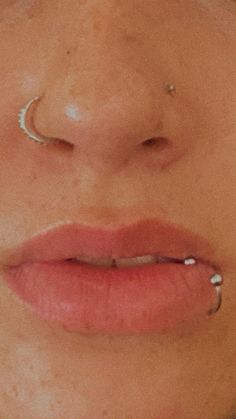 a woman with piercings on her nose and nose ring in front of her face