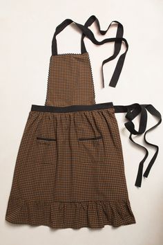 a brown and black checkered apron on a white background with a black ribbon around it