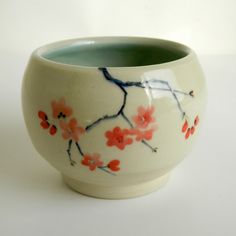 a white bowl with red flowers painted on it