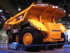 a large yellow dump truck on display in a building