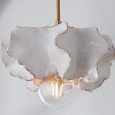 a light that is hanging from a ceiling with a glass ball in the shape of an elephant's head