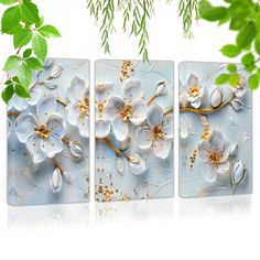 three panels with flowers on them hanging from a tree branch in front of white background