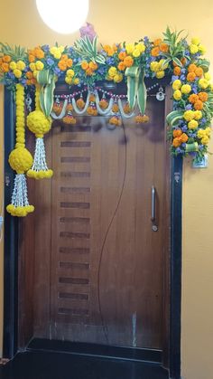 a door decorated with flowers and tassels in front of a light fixture hanging from the ceiling