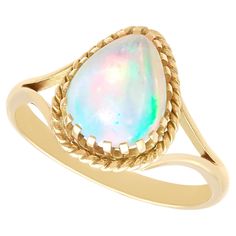 A fine, and impressive vintage 1.80 carat opal and 9 karat yellow gold ring; part of our diverse 1950s gemstone ring collection. This fine and impressive opal ring has been crafted in 9k yellow gold. The impressive claw setting displays a feature 1.80ct cabochon cut white opal, encompassed with a rope twist decorated border. The bifurcated ring shoulders integrate with the setting and blend seamlessly with the plain ring shank. This vintage ring has been independently tested using state of the a Gold Ring Vintage, Plain Ring, Plain Rings, Ring Shank, Rope Twist, Claw Setting, Ring Collection, Opal Ring, Yellow Gold Ring