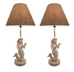 a pair of lamps with mermaid figurines on them