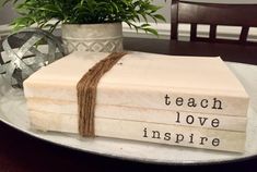 a stack of books sitting on top of a table next to a potted plant