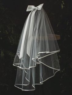 a white veil hanging from the side of a tree