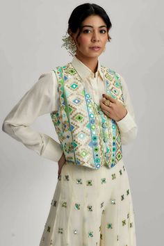 Introducing the exquisite amara jacket set with flared pants, a stunning ensemble that combines traditional craftsmanship with contemporary design. This ensemble features intricate mirror work, pompoms and tassels, along with detailed hand and machine embroidery, making it a true work of art. Bohemian Embroidered Palazzo Set, Elegant Nehru Jacket With Gota Work For Festive Occasions, Bohemian Sharara With Mirror Work For Eid, Bohemian Sets With Gota Work For Eid, Bohemian Gota Work Sets For Eid, Bohemian Sharara With Multicolor Embroidery, Bohemian Embellished Palazzo Set For Navratri, Bohemian Embellished Designer Palazzo Set, Festive Multicolor Embroidered Palazzo Set With Mirror Work