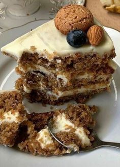 there is a piece of cake with white frosting and nuts on the top slice