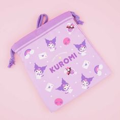 a small purple bag with an owl and skull pattern on the front, sitting on a pink background