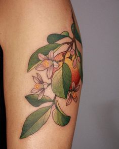 a woman's arm with an apple and flower tattoo on the left side of her body