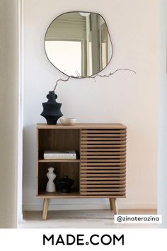 a wooden cabinet with a mirror above it