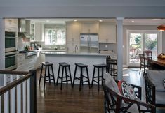 an open kitchen and dining area with bar stools