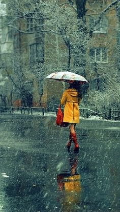 a woman walking in the rain with an umbrella