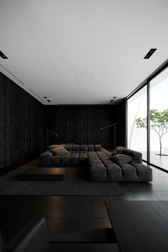 a living room filled with lots of black furniture and large glass doors leading to an outside patio