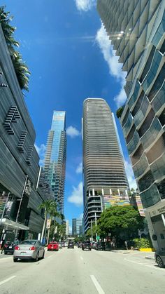 cars are driving down the street in front of tall buildings