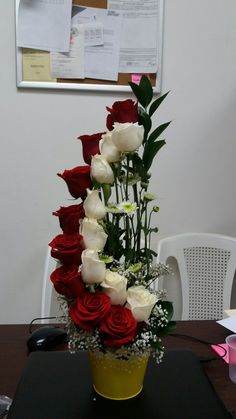 a bouquet of roses in a yellow vase on a table