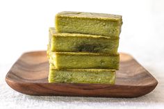 three pieces of green cake sitting on top of a wooden plate