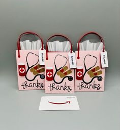 three pink bags with red handles and stethoscopes on them that say thank thanks