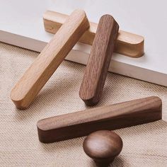 three wooden pegs on the floor next to a door handle and two knobs