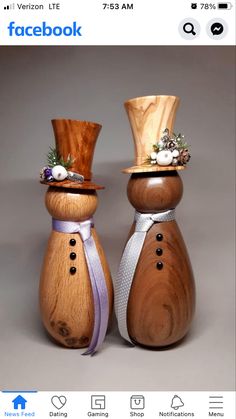 two wooden salt and pepper shakers with top hats on them, one is wearing a purple ribbon