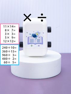 a white clock sitting on top of a table next to a calculator and ruler