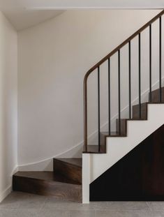 an empty room with stairs and tile flooring