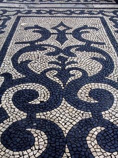 an intricately designed stone floor in the middle of a building with blue and white tiles