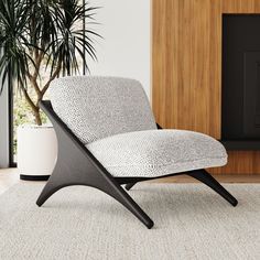 a black and white chair sitting on top of a rug next to a potted plant