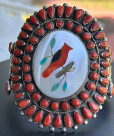 This is a show stopper indeed. This beautiful handmade Zuni Cardinal Inlay includes Mother of Pearl, Coral, Turquoise, Abalone and Jet set in Sterling Silver. Size 6 1/2 Gap 1" 75.3 g/ 2.66 oz Face Size 2 3/4" x 2 1/2" No flex in this cuff. This means no squeezing to make fit or the stones could become compromised. Artisan Red Inlay Jewelry, Artisan Red Jewelry With Inlay, Handmade Southwestern Red Cuff Bracelet, Handmade Red Southwestern Cuff Bracelet, Artisan Red Jewelry For Collectors, Artisan Red Collectible Jewelry, Red Southwestern Cuff Bracelet As Gift, Traditional Red Jewelry For Collectible, Red Southwestern Cuff Bracelet Gift