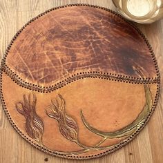 a round leather table mat with two flowers on it