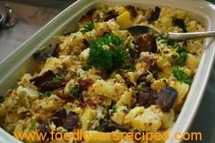 a casserole dish filled with stuffing and garnished with parsley