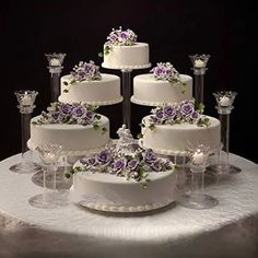 a table topped with lots of white and purple cakes