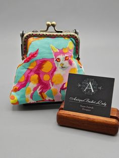 a small purse with a business card holder next to it