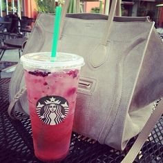 a starbucks drink and handbag sitting on a table