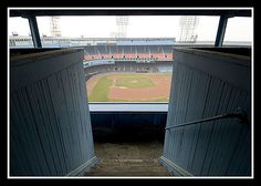 an empty baseball field seen through two open doors